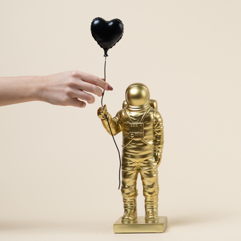 Golden astronaut holding a black heart balloon - Kare Design